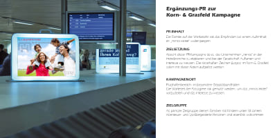 Kofferförmiges Werbedisplay am Flughafen, das das Minos‑Hotel bewirbt.