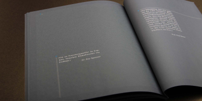 Innenansicht einer Doppelseite mit viel Weißraum auf dunklem Grund. Links steht ein kurzes Zitat von Dr. Roy Spencer in Weiß, während auf der rechten Seite ein längerer Textblock von Prof. Paul Reiter über die wissenschaftliche Arbeit des IPCC informiert.