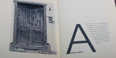Doppelseite zum Kapitel ‚Antike Türen‘. Links eine detailreiche Schwarz-Weiß-Fotografie einer verwitterten, geschlossenen Doppeltür aus Holz. Rechts ein großflächiges ‚A‘ als Gestaltungselement neben einem erklärenden Fließtext.