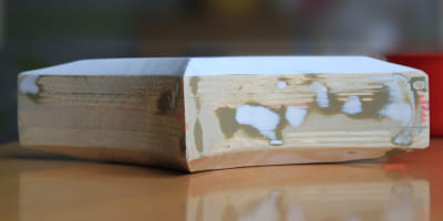 Ein Holzrohling mit gespachtelten und geschliffenen Bereichen, der die Grundform einer späteren Skulptur erkennen lässt.