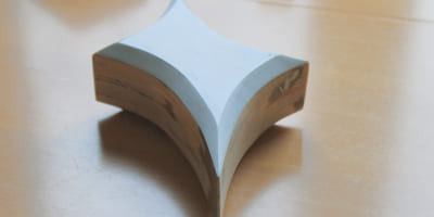 Ein organisch‑geometrischer Rohling mit konkaven Rundungen, teilweise geschliffen und grundiert.