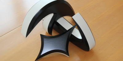 Drei weiß lackierte Skulpturen mit organisch‑geometrischen Formen, nebeneinander arrangiert.